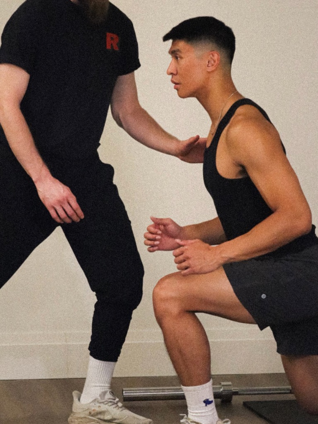 Athletic therapist guiding a client through a functional movement exercise