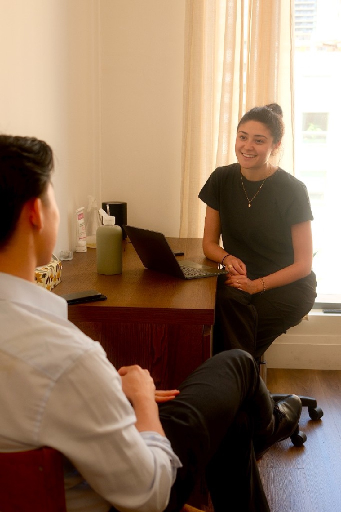 Naturopathic doctor consulting with a patient in a sunlit treatment room